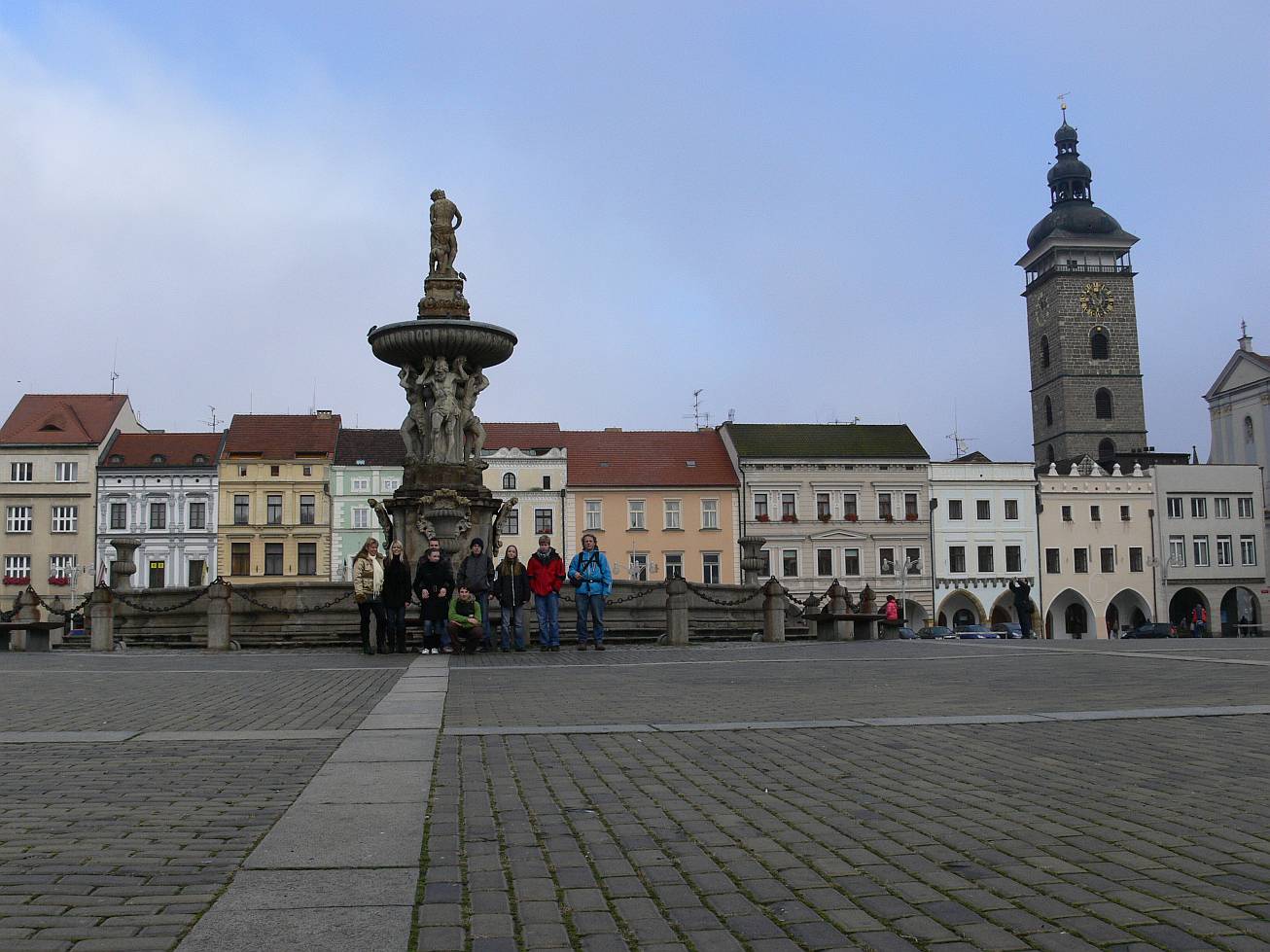 8. Skupinová fotka s kašnou a Černou věží. 
